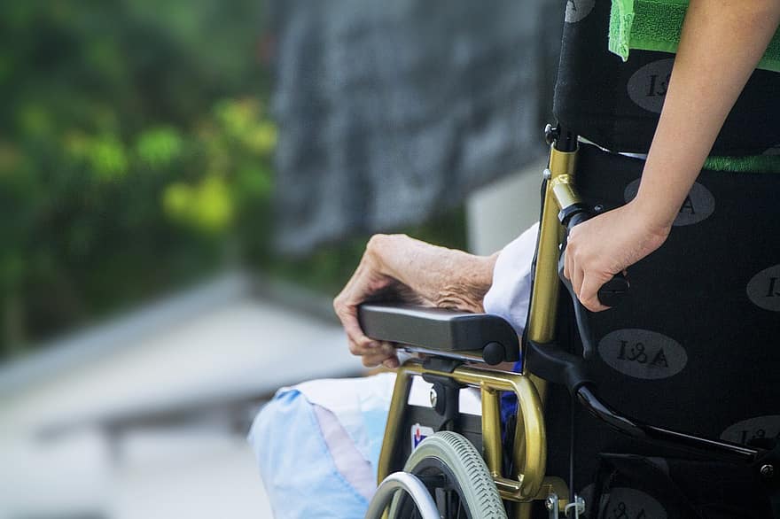 an image of a nurse pushing a wheelchair